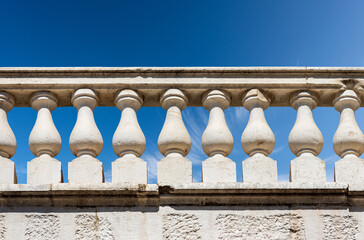 Fototapeta premium Close-up of a white marble balustrade in classical style against a clear blue sky and copy space. Brescia downtown, Lombardy, Italy, Europe.