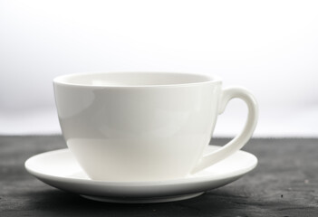 close-up shot of a white porcelain mug on a black background