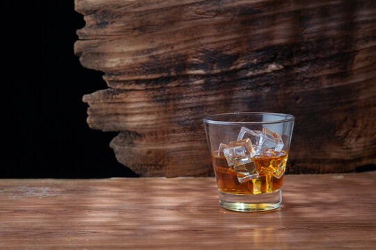 Whiskey or alcoholic beverages or bourbon with ice on the wooden floor and a black and white scene with a top view