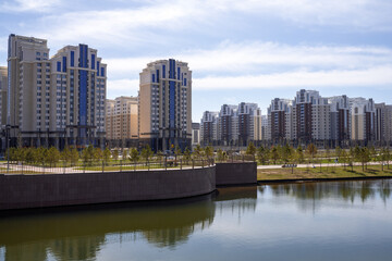 Fototapeta na wymiar Multi-storey buildings along Botanical Graden. Early in spring, Nur-Sultan, Kazakhstan.