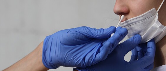 doctor swabbing nose to find traces of the covid-19 virus