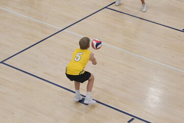 Yellow shirt volleyball player passing ball during game