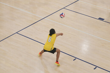 Male volleyball player passes the ball during indoor game