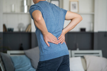 Back pain, kidney inflammation, man suffering from backache at home