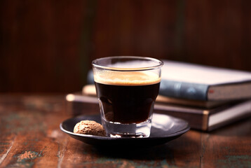 Coffee in glass cup on rustic wooden background. Copy space.