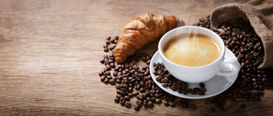 cup of coffee, croissant and coffee beans