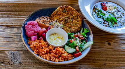 Vegan plate with millet cutlet, bulgur groats and vegetables