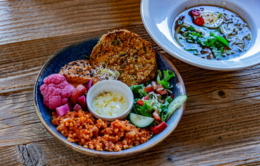 Vegan plate with millet cutlet, bulgur groats and vegetables
