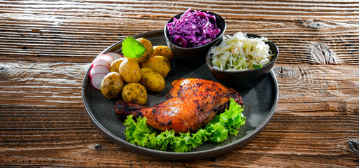 Baked chicken leg with potatoes and vegetable salads