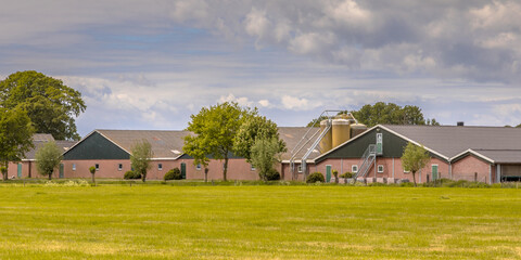 Modern barns of a farm with silos in dutch agricultural landscape