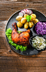 Baked chicken leg with potatoes and vegetable salads