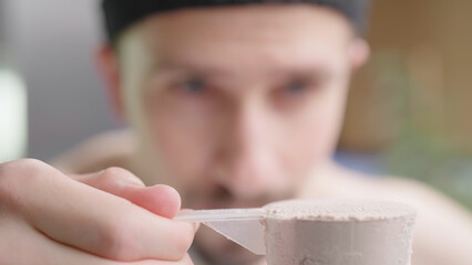 Man measure perfect protein powder ratio removing excess from serving scoop