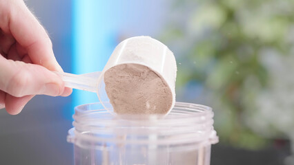 Pour protein powder serving scoop into blender cup