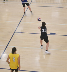 Volleyball player passes free ball during indoor game