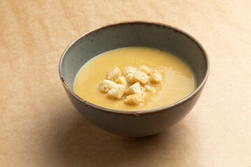 Traditional cream soup with croutons. On a brown background.