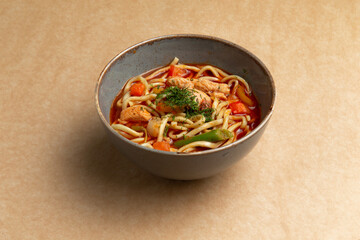 Traditional noodle soup. Lagman. On a brown background.