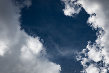 Plane hiding in the clouds with dark blue sky