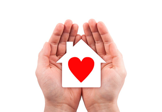 Paper house with red heart cutout in hands isolated on white background with clipping path. 