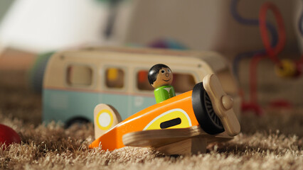 Old vintage wood toys for baby or kids on light brown color carpet which have a airplane bus ball and others.