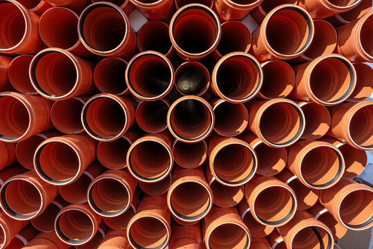 Stack Of Orange Pipe Made Of Polyvinyl Chloride