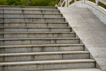 Closeup of stairs on stone arch bridge over lake in park