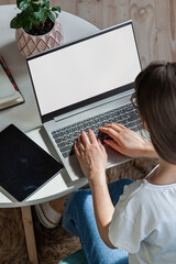Young woman using laptop screen blank, mock up, work home, top view