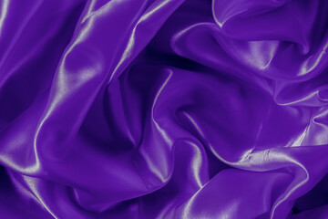 The texture of the proton purple cloth with waves and shrugs. Shiny fabric.