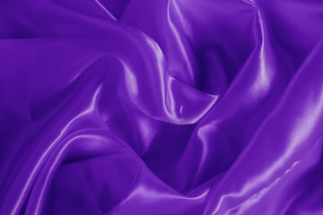 The texture of the proton purple cloth with waves and shrugs. Shiny fabric.