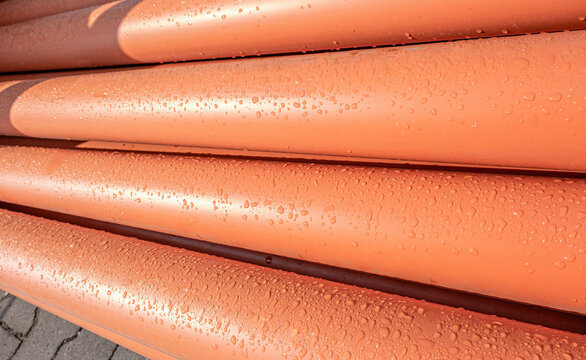 Stack Of Orange Pipe Made Of Polyvinyl Chloride