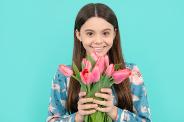 teen girl with spring bouquet on blue background. floral present. happy child face with tulips