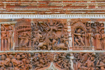 Terracotta decorations depicting Goddess Durga , on the walls at Pratapeswar Temple at Kalna, West Bengal, India. Terracotta is a brownish-red clay that has been baked and is used for making things.