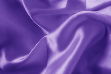 The texture of the proton purple cloth with waves and shrugs. Shiny fabric.