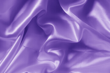 The texture of the proton purple cloth with waves and shrugs. Shiny fabric.