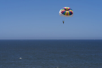 Fototapeta na wymiar Image of a parasailer in mid air, blue sky and sea, shown in Puerto Vallarta, Mexico.