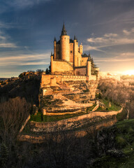 Fototapeta premium Castillo mágico al atardecer, Alcázar de Segovia, Castillo en lo alto de la colina, lugares místicos en España 