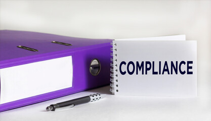 Notepad with Compliance text, on white background with folder and pen