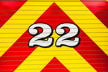 white number 22 outlined in black on bright red and bright yellow chevron pattern graphic detail from fire truck - 500611497