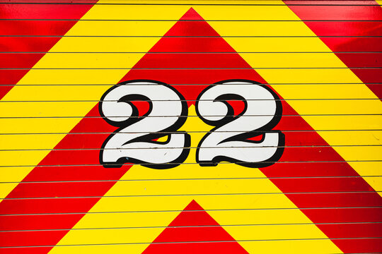 white number 22 outlined in black on bright red and bright yellow chevron pattern graphic detail from fire truck
