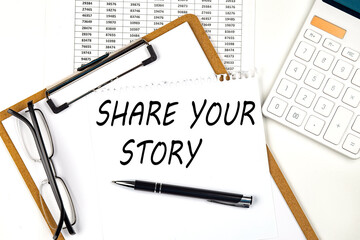 Text SHARE YOUR STORY on the white paper on clipboard with chart and calculator