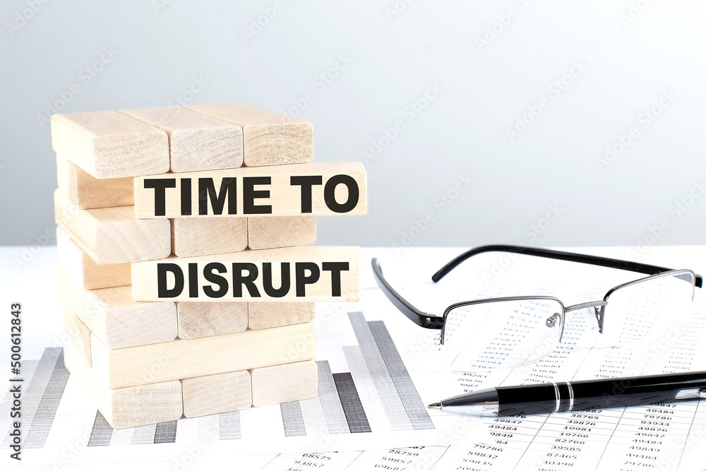 Poster time to disrupt is written on wooden blocks on a chart background