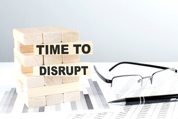TIME TO DISRUPT is written on wooden blocks on a chart background