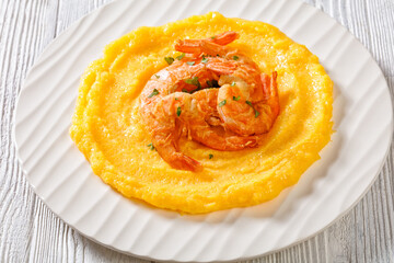 polenta with fried shrimps on plate, top view