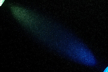 On a black background, short green and long blue rays of light are oncoming in small yellow green grain