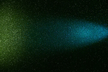 On a dark green gradient background in fine grain, a beam of blue light