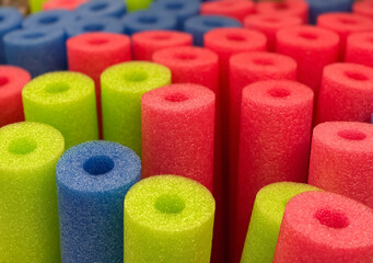 Many colorful pool noodles close up shot , selective focus.