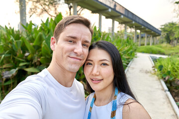 Newlyweb multiracial couple taking a selfie in a uran park during sunset © DavidMorillo