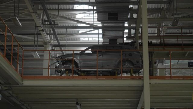 The car frame moves along the conveyor belt.