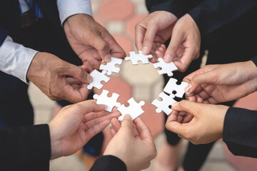 we are compatible A group of businessmen is working on puzzles together.