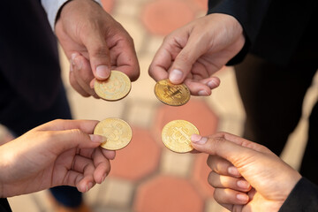 group of businesspeople with bitcoins in hand