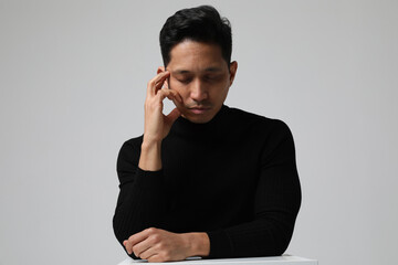 Headshot of Asian young man with closed eyes and calm face expression.